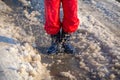 Kid in rainboots jumping in the ice puddle Royalty Free Stock Photo