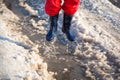 Kid in rainboots jumping in the ice puddle Royalty Free Stock Photo