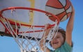 Kid boy basketball player with a ball scoring a goal. Child Player scoring slam dunk, stock photo. Cute smiling boy