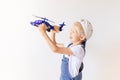Kid boy in blue jeans is playing with a helicopter on background white isolated background, place for text Royalty Free Stock Photo