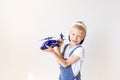 Kid boy in blue jeans is playing with a helicopter on background white isolated background, place for text Royalty Free Stock Photo