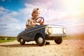 Kid boy driving big vintage toy car with a teddy bear Royalty Free Stock Photo