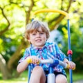 Kid boy driving tricycle or bicycle in garden Royalty Free Stock Photo