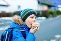 Kid boy eating sweet pie called Kreppel in German or rugelach sufganiyot. Child with cake, religious food for carnival