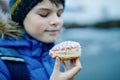 Kid boy eating sweet pie called Kreppel in German or rugelach sufganiyot. Child with cake, religious food for carnival