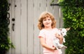 Kid boy feels delighted, carries little puppy dog, expresses tender emotions, Children care and love to small doggy Royalty Free Stock Photo