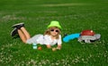 Kid boy girl resting on green grass. Cute kid boy laying on meadow. Happy child playing in summer park. Royalty Free Stock Photo