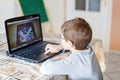 Kid boy with glasses playing online chess board game on computer Royalty Free Stock Photo