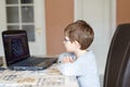 Kid boy with glasses playing online chess board game on computer Royalty Free Stock Photo