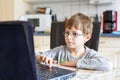 Kid boy with glasses surfing internet and playing on computer Royalty Free Stock Photo