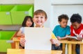 Kid boy holding blank paper with back to school word with diversity friends and teacher at background,Kindergarten school,mock up Royalty Free Stock Photo