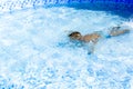 Kid boy holding breath underwater in sunny swimming pool. learning to swim Royalty Free Stock Photo