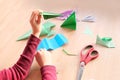 Kid, boy holding model of airplane, folded from white paper using Japanese origami technique, concept of crafting crafts, hobbies