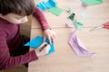 Kid, boy holding model of dinosaur, folded from white paper using Japanese origami technique, concept of crafting crafts, hobbies