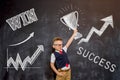 Kid boy holding trophy cup over blackboard. Win, success and leader concept. Back to school. Royalty Free Stock Photo