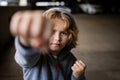 Kid boy in hoodie fighting. Little kid boy fighting outside. Angry little boy showing fist and fighting outdoor Royalty Free Stock Photo
