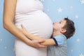 Kid boy hugging pregnant mother`s belly. Happy kid boy hugging pregnant mother`s belly, pregnancy. New life concept