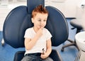Kid boy in modern dental chair plays with a dental mirror and smiles