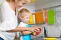 Kid boy and mother washing dishes - having fun together in the kitchen Royalty Free Stock Photo