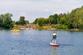 Kid boy paddling on sup board on a lake. Active child on modern trendy stand up paddle board. Summer outdoors vacations Royalty Free Stock Photo