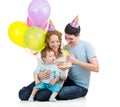 Kid boy with parents celebrating birthday and blowing candles o