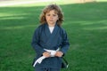 Kid boy practicing karate outdoor. Sport karate kids. Little boy wearing kimono doing karate in park. Little karate Royalty Free Stock Photo