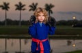 Kid boy practicing martial arts outdoor. Sport martial arts, boxing kids. Little boy wearing kimono doing boxing in park