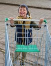 Kid boy pushing empty shopping cart at parking lot Royalty Free Stock Photo