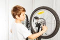 Kid boy repairing his bicycle at garage