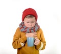 Kid boy is sick with cup of tea isolated on white background. Child in scarf and hat coughs. San unhappy school kid face