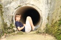 Kid - boy sitting in sluice-way