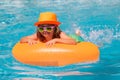 Kid boy splashing in swimming pool having fun, leisure activity. Kid swim in swimming pool. Water sport activity on