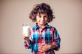 Kid boy with stomach pain holding a glass of milk. Dairy Intolerant person. Children, health care concept