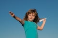 Kid boy throwing a paper plane with blue sky background. Royalty Free Stock Photo