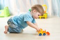 Kid boy toddler playing with toy car