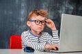 Kid boy using laptop computer at his online lesson at school Royalty Free Stock Photo