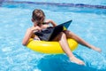 Kid boy using laptop in the swimming pool. Technology, summer and vacation concept Royalty Free Stock Photo