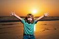 Kid boy walking to beach, raised hands. Amazed surprised kids emotions.