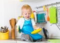 Kid boy washing dishes and having fun in the Royalty Free Stock Photo