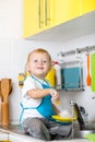 Kid boy washing dishes and having fun in the Royalty Free Stock Photo