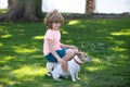 Kid caress dog. Child boy with dog walking outdoor. Kid playing with puppy. Children with pet friend. Royalty Free Stock Photo