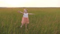 Kid catches a butterfly in meadow in spring. Happy little girl runs across green field with outstretched arms. Child Royalty Free Stock Photo