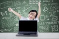 Kid celebrate her achievement with laptop in class Royalty Free Stock Photo