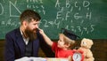 Kid cheerful distracting while studying, attention deficit. Naughty child concept. Father with beard, teacher teaches Royalty Free Stock Photo