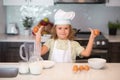 Kid chef cook with eggs at kitchen. Chef kid boy baking on the kitchen. Child chef cook prepares food at kitchen. Kids Royalty Free Stock Photo