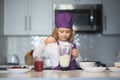Kid in chef hat and apron. Child making tasty delicious. little boy in chef hat and an apron cooking in the kitchen. Royalty Free Stock Photo