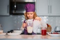 Kid in chef hat and apron. Child making tasty delicious. little boy in chef hat and an apron cooking in the kitchen. Royalty Free Stock Photo