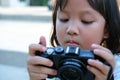 Kid, Child, Asian little girl holding and looking at the digital camera, learn how to take a photo Royalty Free Stock Photo