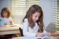 Kid in classroom at school. Happy schoolchild sitting at desk, class. Education, elementary school, learning and people