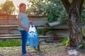 Kid cleaning in park.Volunteer child with a garbage bag cleaning up litter, putting plastic bottle in recycling bag. Royalty Free Stock Photo